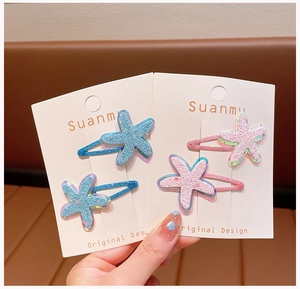 Detailed close-up of glittery starfish hair clips in pink and blue colors for girls
