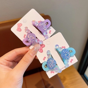 Vue détaillée des pinces à cheveux coquillage irisé en ensembles violet et bleu