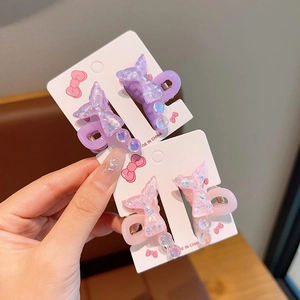 Détail de petites pinces à cheveux queue de poisson pailletées en rose et violet