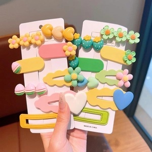Detailed view of macaron colored flower and heart resin hair clips set for girls