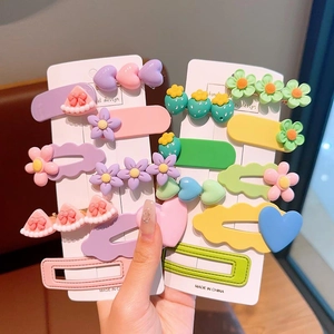 Macro view of colorful floral and heart hair clips on display cards in hand