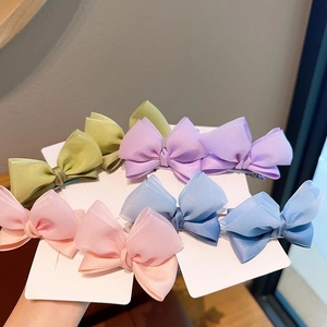 Detailed view of layered macaron fabric bow hair clips with soft mesh texture