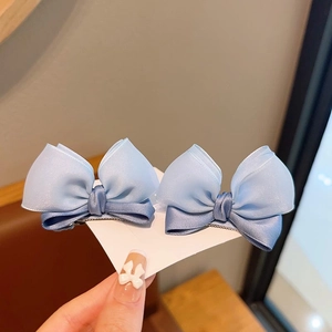 Detailed view of dual-layer blue gradient silk bow hair clips on display card