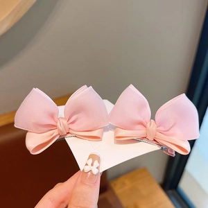 Detail view of pink chiffon double-layered bow hair clips with silver alligator base