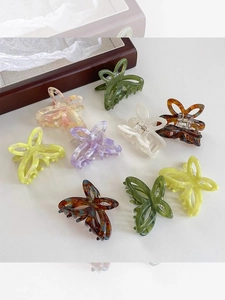 Detail view of colorful butterfly hair claws in acetate with marbled texture and metal springs