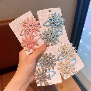 Dettaglio di fermagli a fiocco di neve con paillettes glitterate e strass per bambine