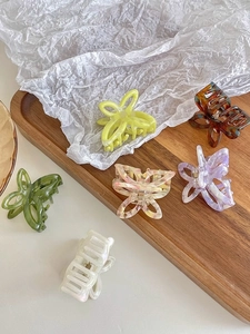 Assorted butterfly and rectangular acetate hair claws in various vibrant colors and textures
