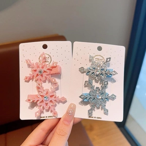 Dettaglio di fermagli per capelli a fiocco di neve glitterati con strass rosa e blu