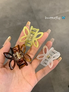 Three butterfly hair claws in amber, yellow, and white acetate finish with metal spring
