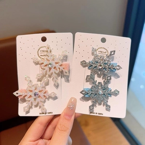 Dettaglio di fermagli per capelli a fiocco di neve con glitter e strass su carta