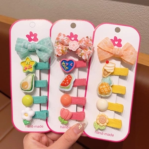 Detailopname van stoffen haarspeldjes voor kinderen met kleurrijke fruit en bloemen
