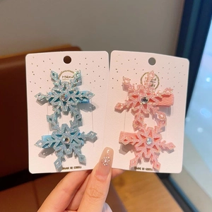 Dettaglio di fermagli per capelli a fiocco di neve glitterati per bambine con strass blu e rosa