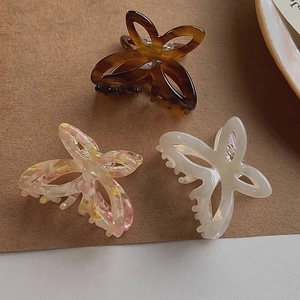 Detailed macro view of three butterfly hair claws in marble and tortoiseshell patterns