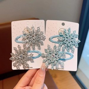 Dettaglio di fermagli per capelli a fiocco di neve glitterati in argento e blu per bimba