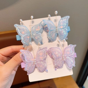 Vue détaillée de quatre barrettes papillon en dentelle avec paillettes et perles
