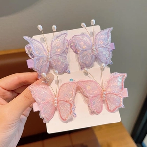 Gros plan de quatre pinces à cheveux papillon brodées 3D avec perles sur cartes