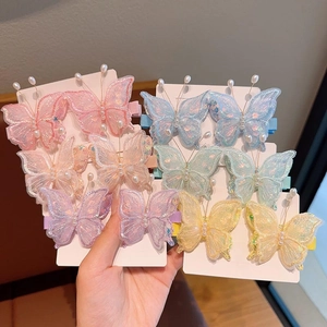 Détail des pinces à cheveux papillon brodées avec perles et résille pour fillettes