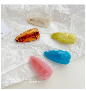 Flat lay of five colorful water-drop hair clips with unique marble textures