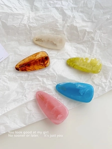 Detail showing five-piece colorful teardrop acetate hair clips with marble texture
