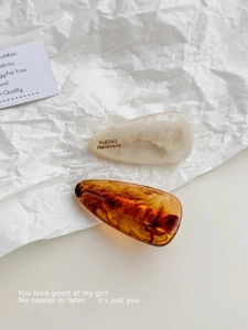 Close-up of marble and amber tortoiseshell hair clips set on a minimalist white background