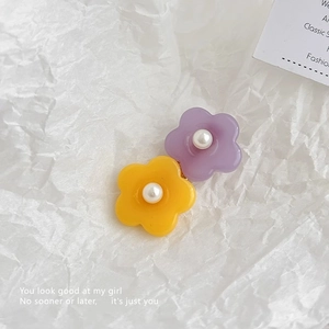 Gros plan de barrettes à fleurs violettes et jaunes avec perles sur fond de papier