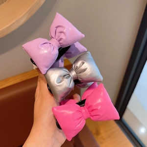 Detailed view of three metallic PU leather bow hair clips in purple, silver, and rose pink