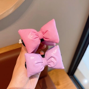Close-up of pink and purple quilted bow hair clips with soft 3D puffy design