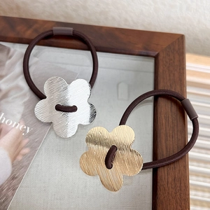 Elegant metal flower hair ties in gold and silver with brushed texture and elastic band