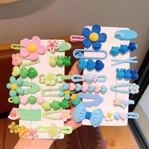 Détail d'un lot de barrettes colorées aux motifs fleurs et animaux pour petites filles