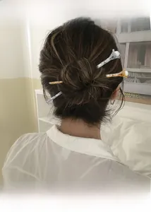 Detail of elegant gold and silver branch hairpins with pearls in a high bun hairstyle