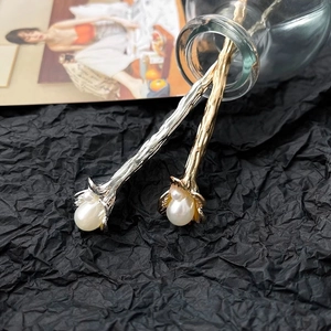 Detailed view of vintage flower hairpins with pearls and irregular textured metal finish