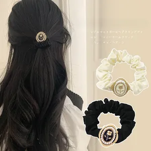 Detail of vintage French satin hair scrunchie with rose relief and pearl embellishments