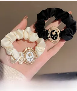 Close-up of French vintage satin scrunchies with elegant faux pearl and metal ornaments
