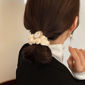 Detail of cream satin hair scrunchie with vintage floral cameo and pearl embellishments