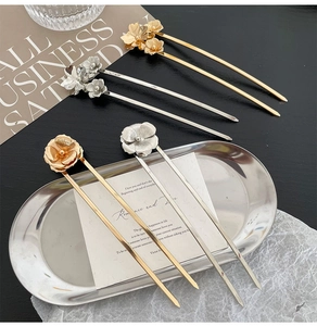 Detailed view of vintage gold and silver flower hair pins with intricate metallic petals