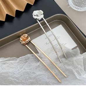 Detail of gold and silver U-shaped hairpins with brushed metal flower texture