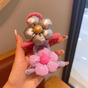 Detailed close-up of colorful 3D flower hair clips with glossy finish and knit base