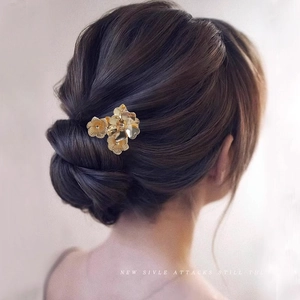 Golden flower hair clip for bun styling on dark hair, minimalist traditional hair pin
