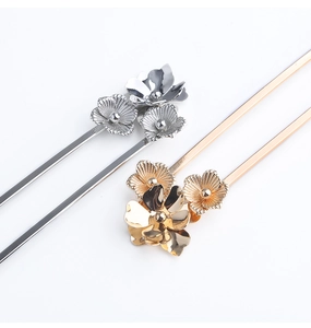 Detail of silver and gold metal flower hair pins with intricate petal textures for buns