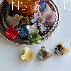Detail shot of acetate bear-shaped hair clips with France Handmade text on tray