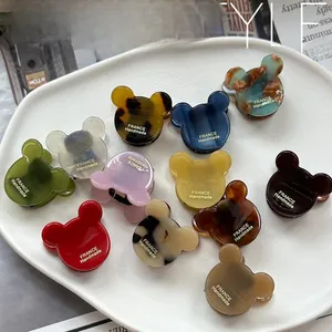 Macro detail of bear head acetate hair clips in multiple colors with gold lettering