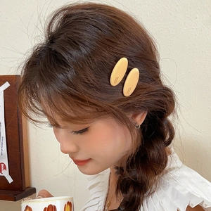 Gros plan de barrettes ovales jaune mat avec gravure France Handmade sur le modèle