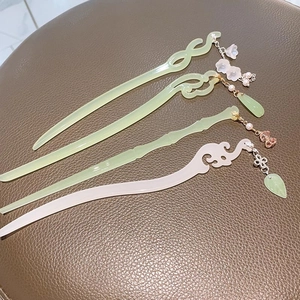 Detail view of retro lily of the valley hairpins with tassels and jade-like texture