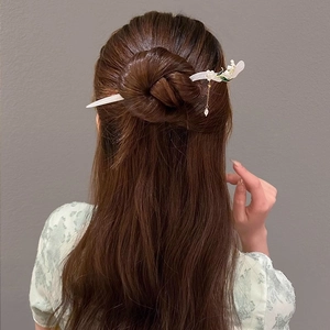 Detail view of Lily of the Valley hair pin with white flowers and pearl tassel charm