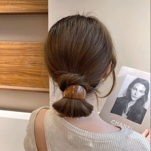 Chic amber acetate hair cuff for elegant low ponytail styling on a woman