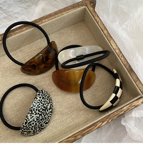 Close-up of acetic acid oval hair ties with tortoiseshell and checkerboard patterns