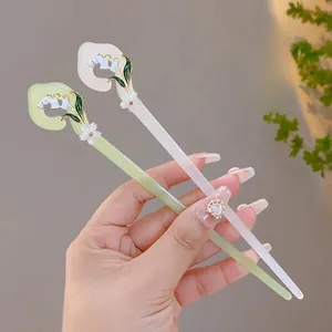 Detail view of vintage lily of the valley hair pins in light green and cream white colors