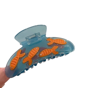 Blue translucent fish hair claw clip with orange fish accents and rhinestones