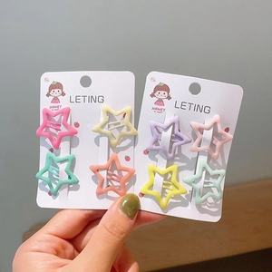 Close-up of star-shaped macaron colored metal hair clips set on cute cardboard cards