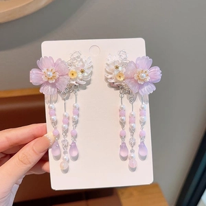 Close-up of pink flower hair clips with long beaded tassels and pearl center detail